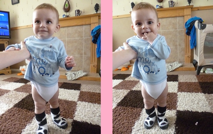 Two side-by-side photos show a baby standing indoors on a patterned carpet, wearing a light blue shirt, white nappy, and black-and-white socks. An adult hand supports the baby in both images.