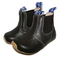 A pair of black leather SKEANIE Shoes ankle boots for children with white stitching, light brown soles, stretchy side panels, and blue fabric pull tabs at the back.