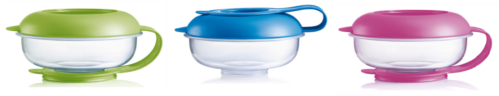 Three clear plastic MAM Snack Box bowls with coloured lids and handles are shown side by side. The bowls feature green, blue, and pink lids, each matching its base or handle, arranged on a white background.
