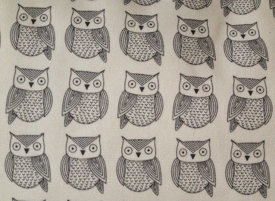 A repeating pattern of hand-drawn black and white owls with geometric details on a light background, inspired by Pink Lining’s Blooming Gorgeous Changing Bag. Each owl has large eyes, pointed ears, and patterned wings and bodies.