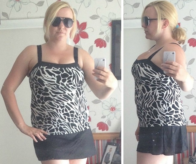 A woman with blonde hair in a ponytail, wearing sunglasses and a Miraclesuit Tankini top with a Tankini Skirt, takes mirror selfies from the front and side in a room with floral wallpaper.
