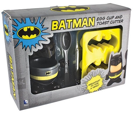Boxed Batman-themed breakfast set with an egg cup shaped like Batman, yellow toast cutter with bat symbols, black spoon, and Batman artwork—an ideal pick for Christmas Gifts for older boys. Text reads "BATMAN Egg Cup and Toast Cutter.