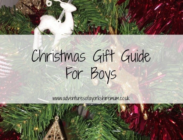 A close-up of a decorated Christmas tree with tinsel and baubles, featuring text overlay: "Younger Boys’ Christmas Gift Ideas" and a website link: www.adventuresofyorkshiremum.co.uk.