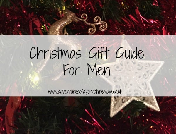Christmas tree adorned with red tinsel, a glittery reindeer, and a white star ornament. Overlaid text reads: “Christmas Gift Guide For Men – perfect Christmas Presents at www.adventuresofyorkshiremum.co.uk”.