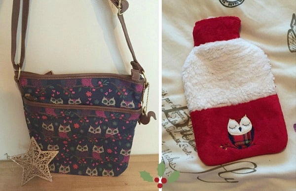 A purple crossbody bag with an owl pattern sits next to a red and white hot water bottle cover featuring two embroidered owls—perfect Christmas presents for women—both displayed on a wooden surface and patterned fabric.