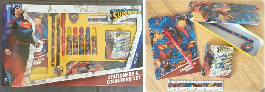 A great Christmas gift idea for younger boys, this Superman-themed stationery and colouring set includes pencils, crayons, a ruler, rubber, sharpener, colouring book, and metal pencil case, all displayed in its packaging and arranged outside on a table.