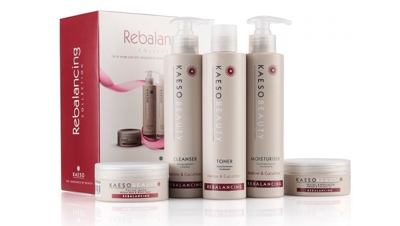 A set of Kaeso Beauty Rebalancing skincare products, including cleanser, toner, moisturiser in pump bottles, and two jars, displayed in front of the product’s red and white packaging box—perfect for Christmas presents or featured in any Christmas gift guide.