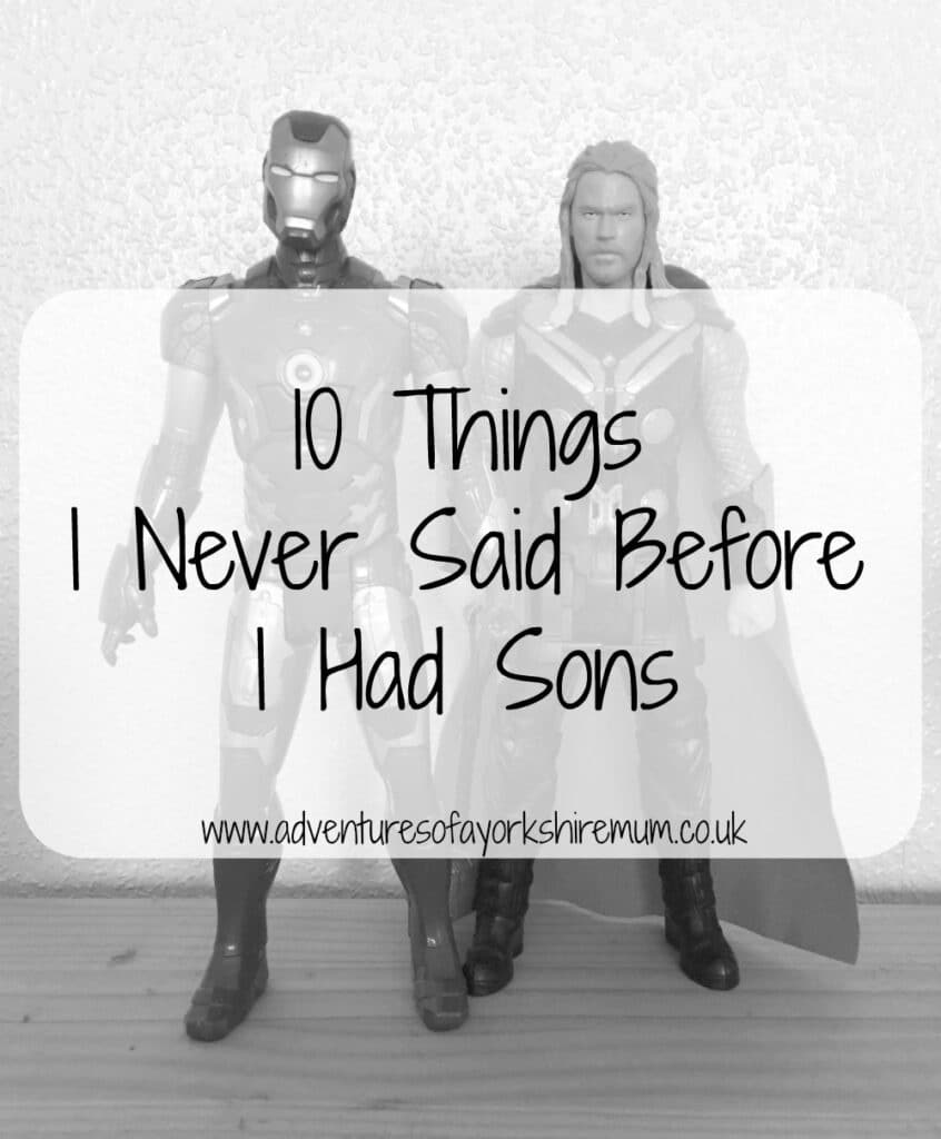 Two action figures, Iron Man and Thor, stand side by side on a wooden surface. Overlaid text reads, "10 Things I Never Said Before Parenting Boys www.adventuresofayorkshiremum.co.uk".