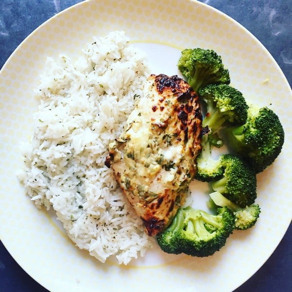 A plate with three sections: steamed white rice, a piece of grilled seasoned chicken breast, and several florets of steamed broccoli—just like a balanced meal from HelloFresh.