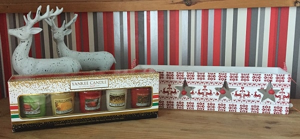 A festive Christmas display with two white decorative reindeer, a box set of Yankee Candle votive candles, and a rectangular white box with red patterns and star cut-outs—perfect seasonal décor for house or home décor accents.