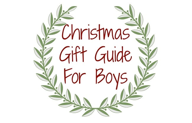 A green leafy wreath frames the handwritten text “Christmas Gift Guide For Boys” in red letters on a white background, offering festive present ideas for younger boys.
