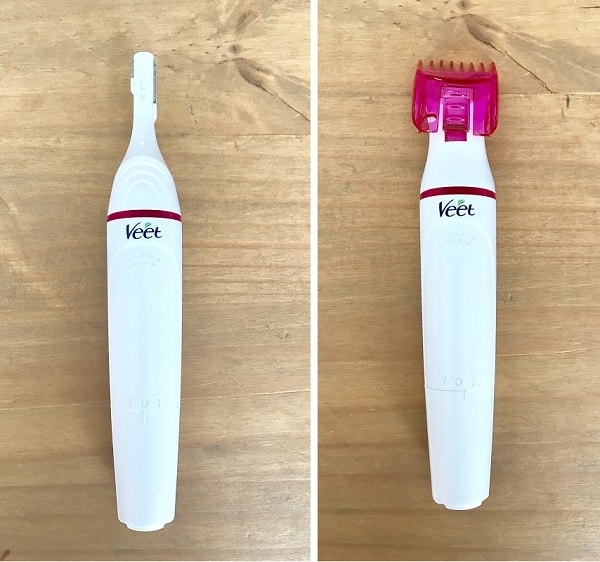 Two white Veet electric trimmers, perfect for hair essentials, are displayed side by side on a wooden surface; the left features a narrow blade, whilst the right has a pink comb attachment for a salon look at home.