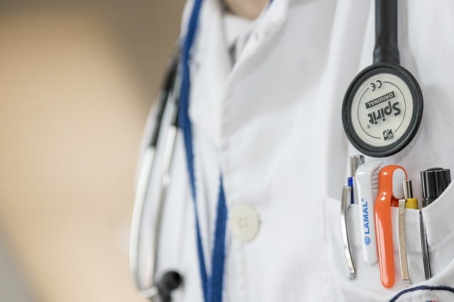 A close-up of a person in a white lab coat, with a stethoscope and several pens in the pocket—ideal for professionals discussing facelift results or cheek implants. The focus is on the chest area, not showing the person's face.