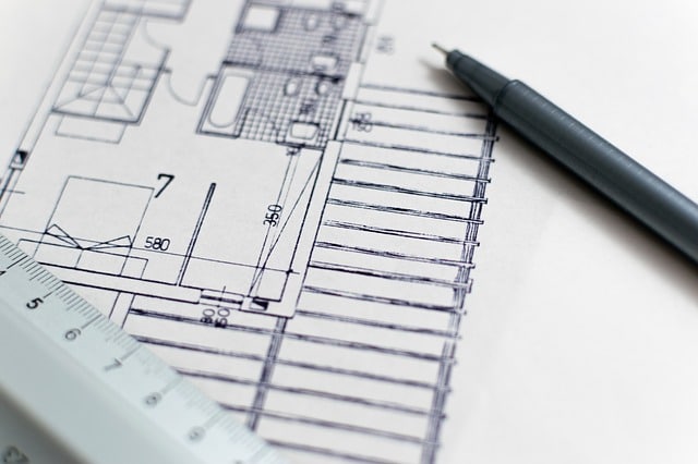 A close-up of an architectural floor plan drawing with a pen and ruler atop the paper, illustrating extension planning and clever ways of making space for a growing family.