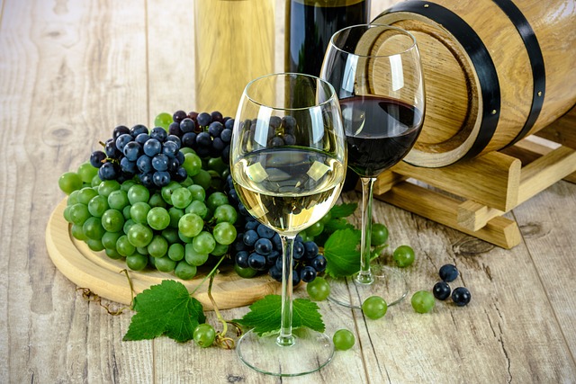 Two glasses of wine, one white and one red, are placed on a wooden table next to bunches of grapes, a wine barrel, and bottles—capturing the elegance and evolving tastes in the food and drink industry.