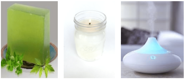 A green bar of soap with leaves, a lit candle in a glass jar, and a white essential oil diffuser emitting mist—perfect for creating a relaxing atmosphere and ideal as thoughtful 50th Birthday Presents.