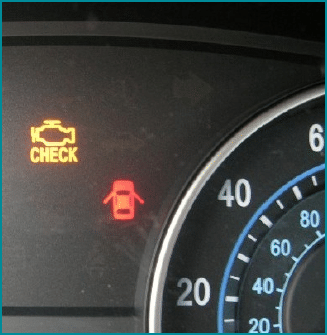 Close-up of a car dashboard showing a yellow check engine light and a red door open indicator next to the speedometer, reminding drivers to resolve issues to pass MOT.
