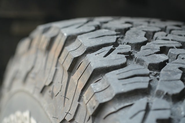 Close-up view of a rugged tyre with deep, textured treads, showing signs of use and wear. The detailed tread pattern highlights the tyre tread depth, making it easy to check tyre condition using the 20p method for off-road or all-terrain durability.