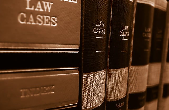 Close-up view of several large, leather-bound law books standing upright on a shelf, with "Law Cases" and "Index" in gold lettering—essential resources when handling a medical negligence compensation claim for someone else.