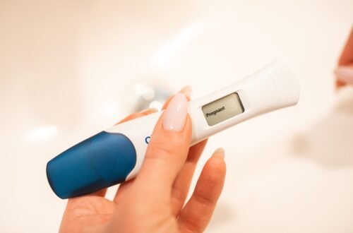 A woman holding a positive pregnancy test