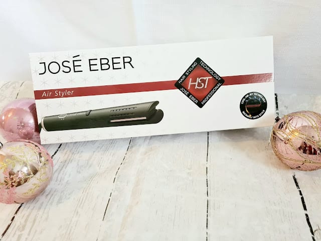 A José Eber Air Styler box is displayed on a white wooden surface, surrounded by pink and gold ornaments—making it a perfect addition to your list of Christmas gifts for adults.