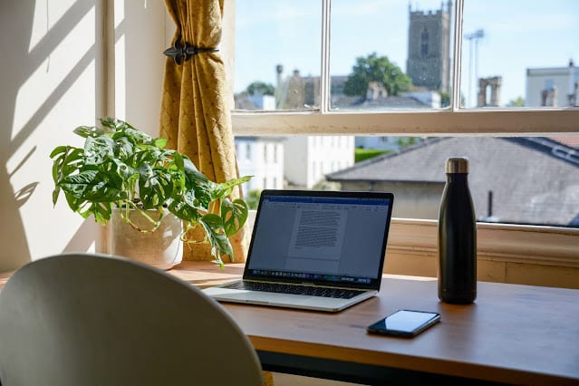 A home office set up in front of a window