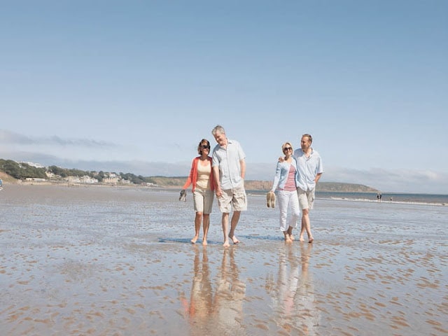 4 adults walking on a beach in Yorkshire