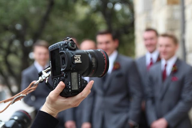 A photographer taking pictures of the groomsmen at a wedding
