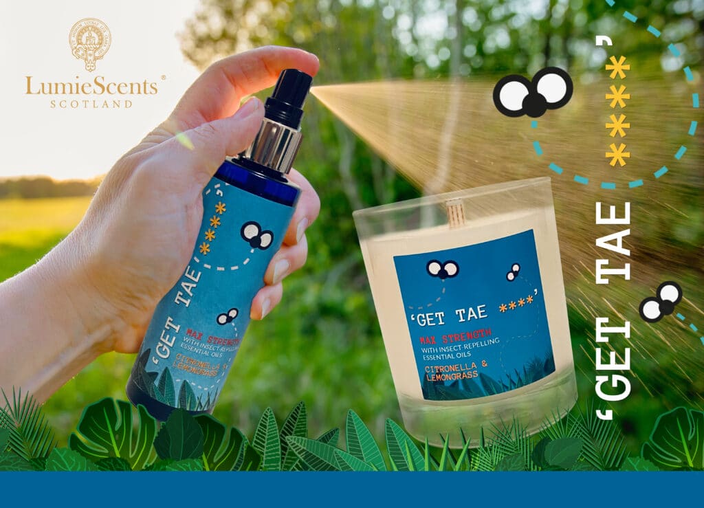 A hand sprays a blue "GET TAE *" bottle beside a candle with a matching label. Outdoors amid greenery, illustrated flies and bold “GET TAE *” text pop. LumieScents Scotland logo shines—perfect for a summer prize giveaway!.