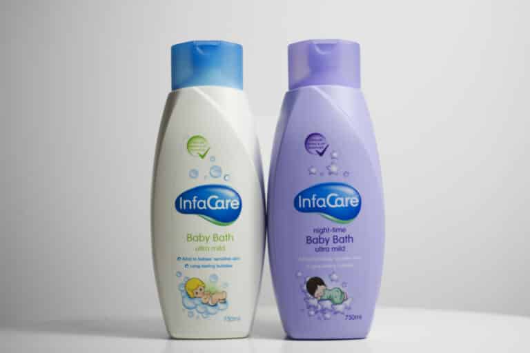 Two Infacare products stand side by side: the white bottle with a blue cap labelled "Baby Bath ultra mild", and the purple bottle with a lavender cap labelled "Night-time Baby Bath ultra mild.