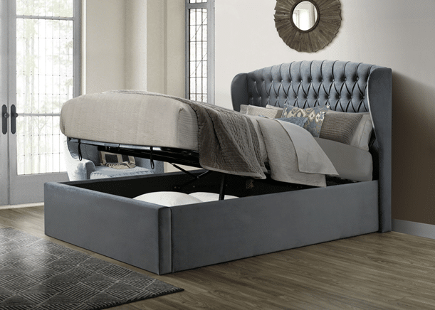 This grey upholstered bed with a tufted headboard is one of 10 bed frames guaranteed to impress guests, featuring a lift-up mattress for hidden storage and stylish neutral bedding with decorative cushions.