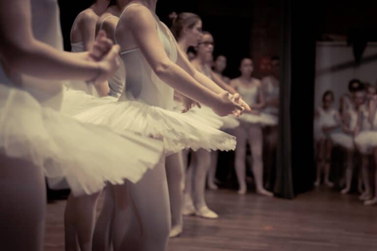 a group of young ballet dancers getting ready to go on stage to perform