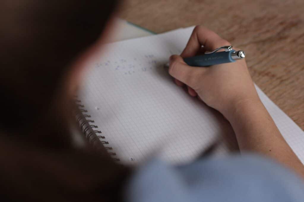 A student writing in a notebook