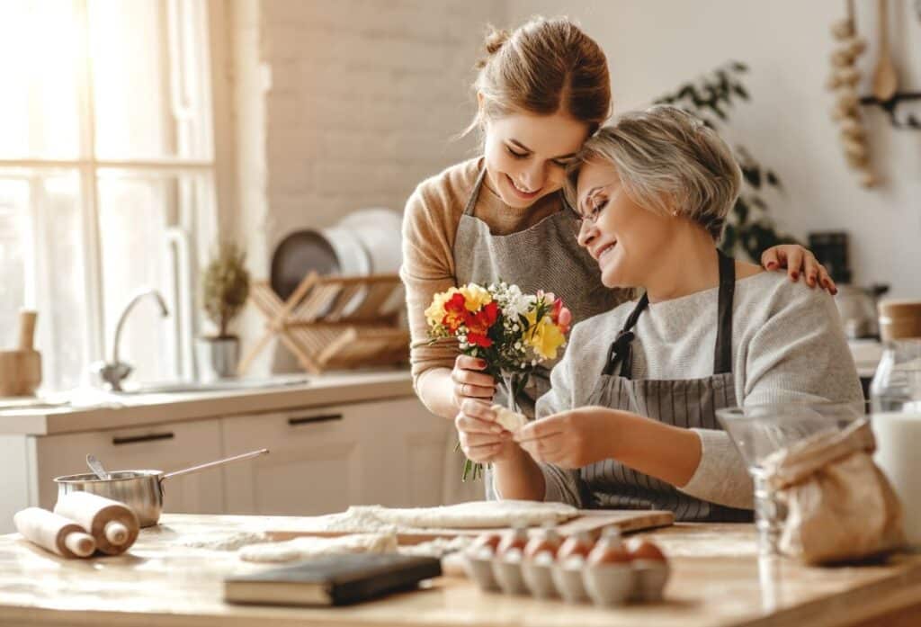 A young woman giving an older woman a bouquet of flowers