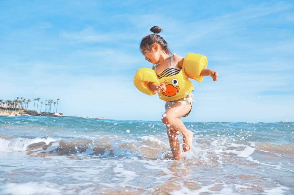 A small child playing in the sea on holiday