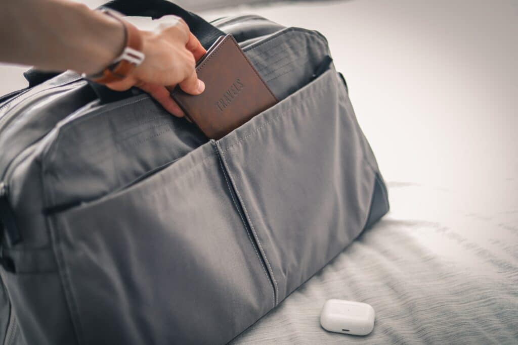 Someone packing a gray bag for a journey
