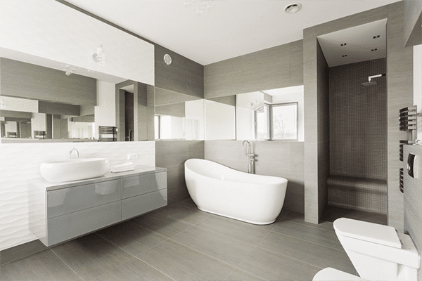 Modern bathroom with a freestanding white bath, floating sink vanity with mirror, walk-in shower, and toilet. Stylish vinyl flooring complements the neutral tones, clean lines, and contemporary fittings throughout.