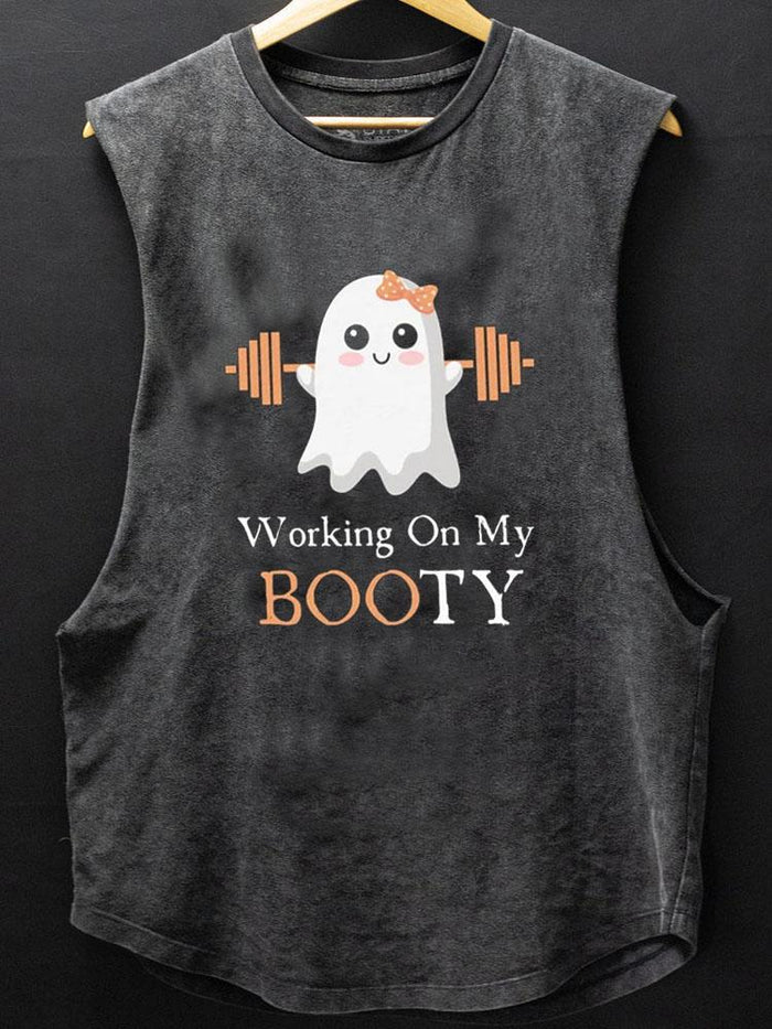 A sleeveless black vest hangs on a wooden hanger. The top, from IronPandaFit, features a cute ghost lifting orange barbells, wearing an orange bow, with the text "Working On My BOOTY" printed below.