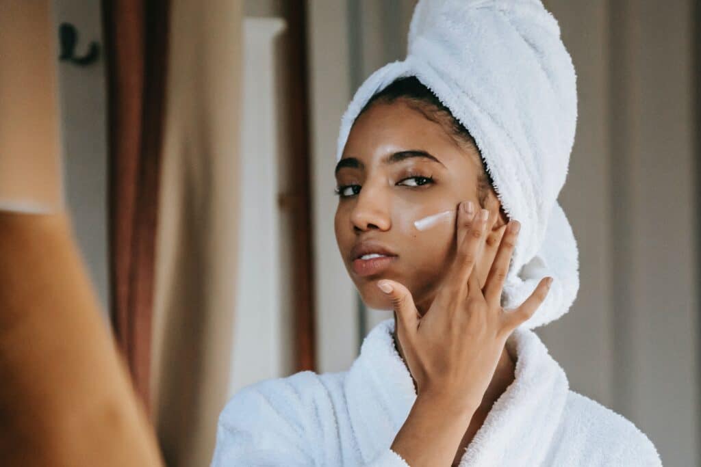 A woman with beautiful skin putting on a face cream