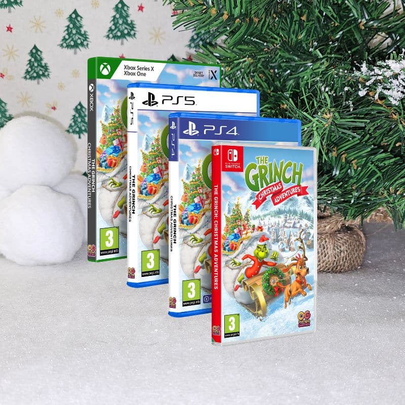 Four video game cases of "The Grinch: Christmas Adventures" for Nintendo Switch, PS4, PS5, and Xbox stand on snowy ground near a decorated Christmas tree and snowballs, creating the perfect festive Christmas backdrop.