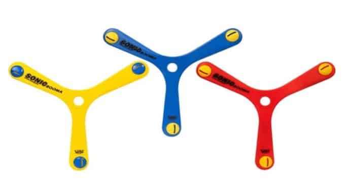 Three plastic boomerangs in yellow, blue, and red, each with three rounded arms and a circular hole in the centre, are arranged on a white background—perfect as a fun stocking filler for kids.