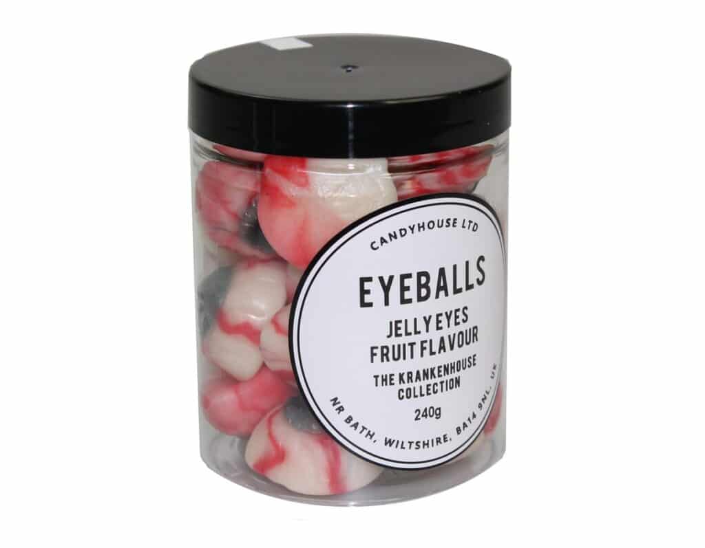 A clear plastic jar with a black lid contains red, white, and black jelly sweets shaped like eyeballs—perfect as a spooky stocking filler. The label reads: “EYEBALLS Jelly Eyes Fruit Flavour, The Krakenhouse Collection, 240g.”.