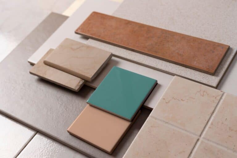 Various ceramic and porcelain tiles in different colours, shapes, and finishes are arranged in overlapping layers—perfect inspiration for homeowners seeking tile renovation ideas with beige, grey, teal, peach, and terracotta tones.