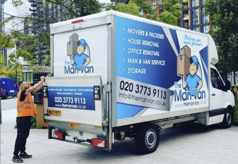 A worker in a high-visibility vest operates the tail lift of a Man-Van removals lorry on a city street, displaying services to assist with relocating to the North.